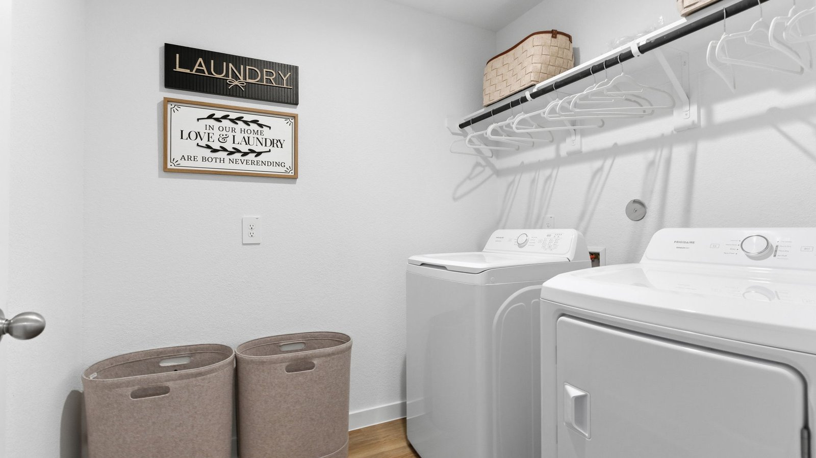 A laundry room featuring a washer and dryer, neatly arranged with ample space for laundry tasks and storage.