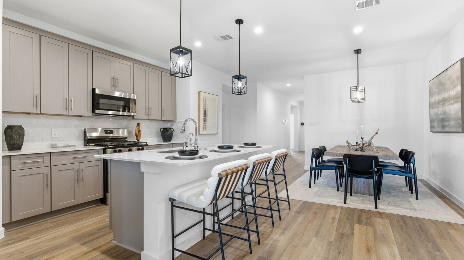 Bright and spacious kitchen with quartz countertops, stainless steel appliances, and an island with bar seating.