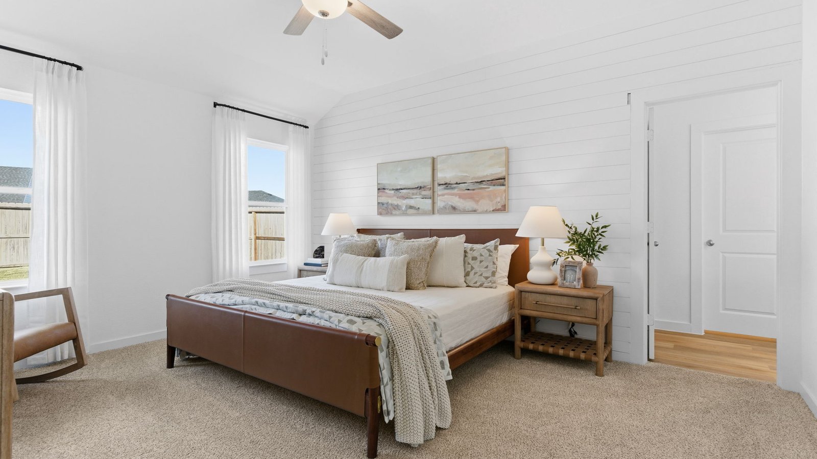 A spacious primary bedroom emphasizing open space and natural lighting with large windows.