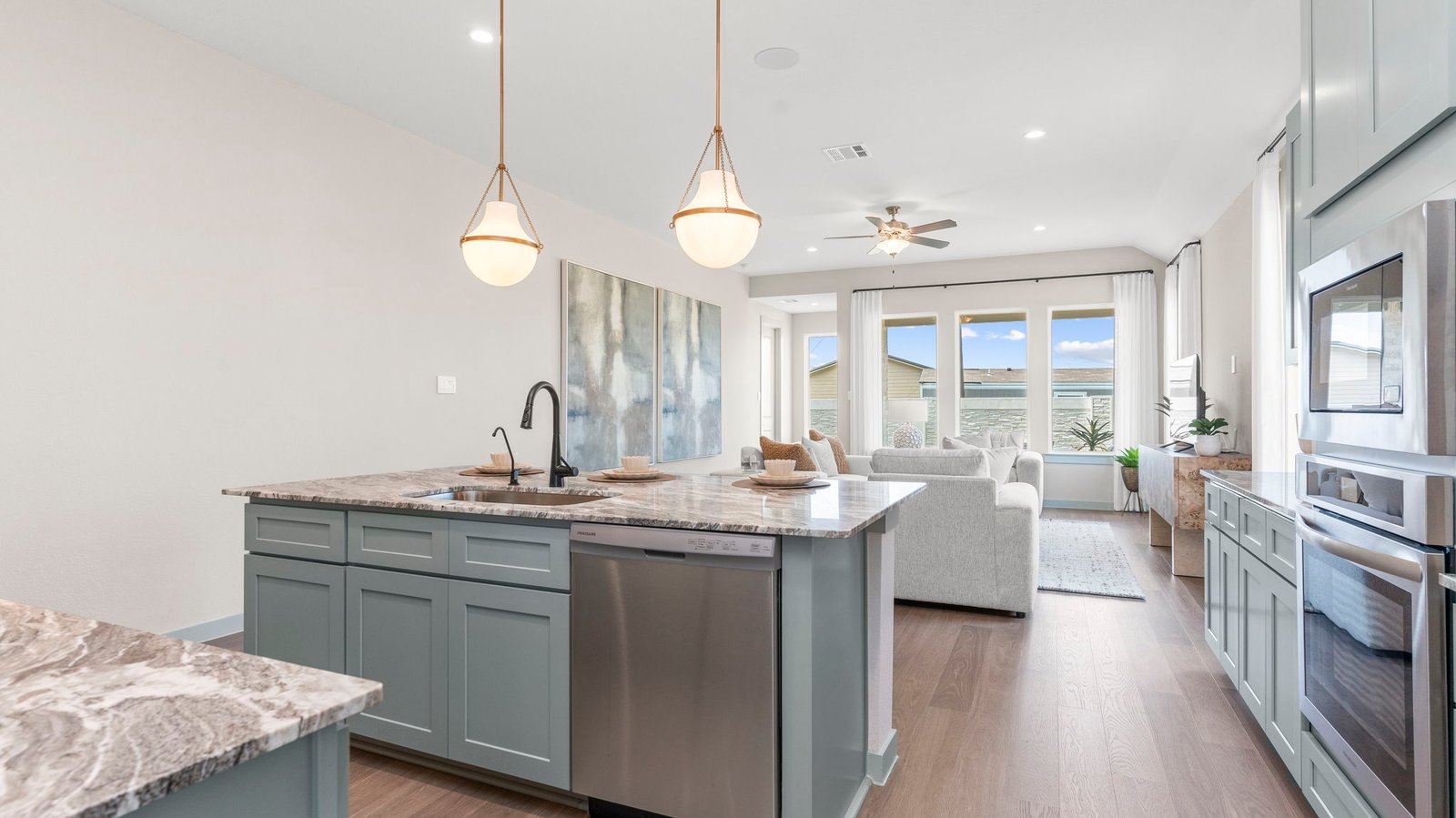 Bright and spacious kitchen with quartz countertops, stainless steel appliances, and an island with bar seating.
