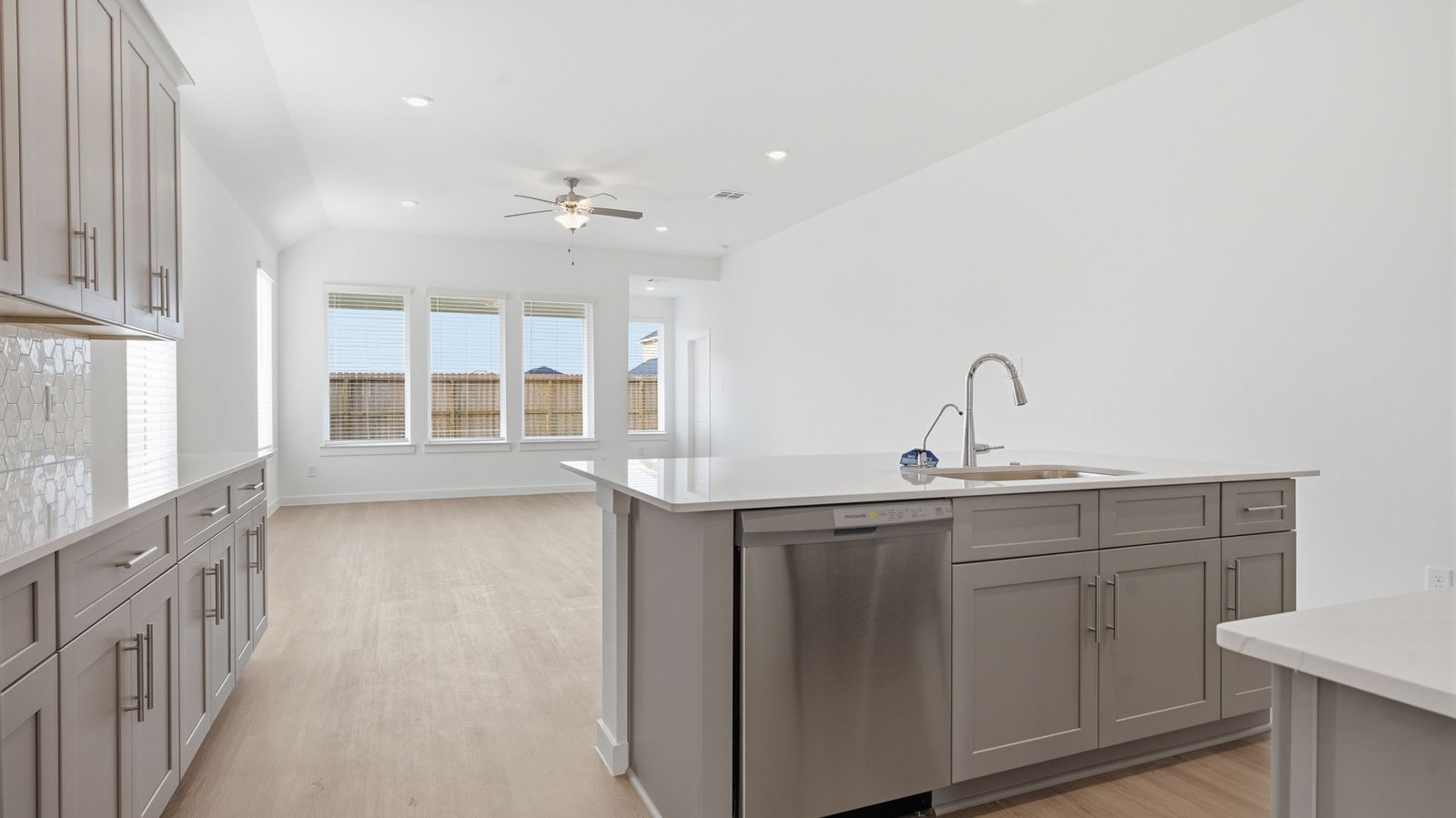 Bright and spacious kitchen with granite countertops, stainless steel appliances, and an island with bar seating.