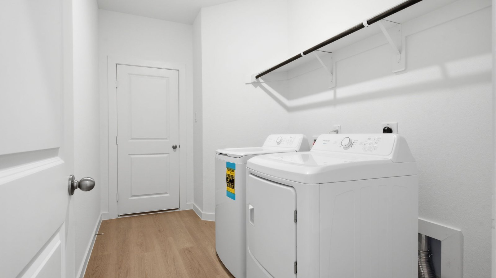 Spacious laundry room with washer and dryer connections, hanging rod, and vinyl wood flooring