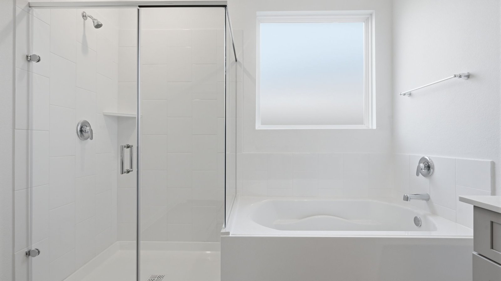 Luxurious primary bathroom with dual vanities, a soaking tub, glass-enclosed shower and walk-in closet.