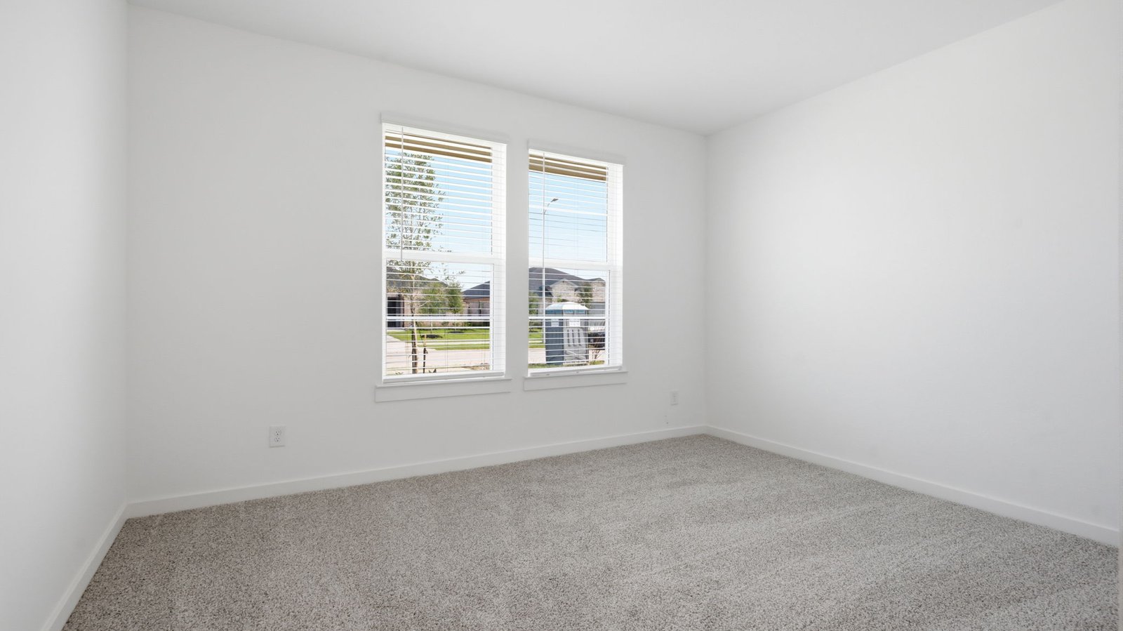 Comfortable guest bedroom featuring neutral-toned walls, carpeted flooring, and a separate closet.