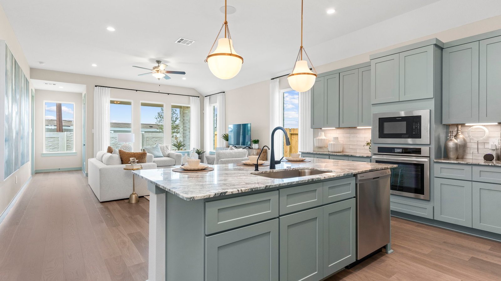 Bright and spacious kitchen with quartz countertops, stainless steel appliances, and an island with bar seating.