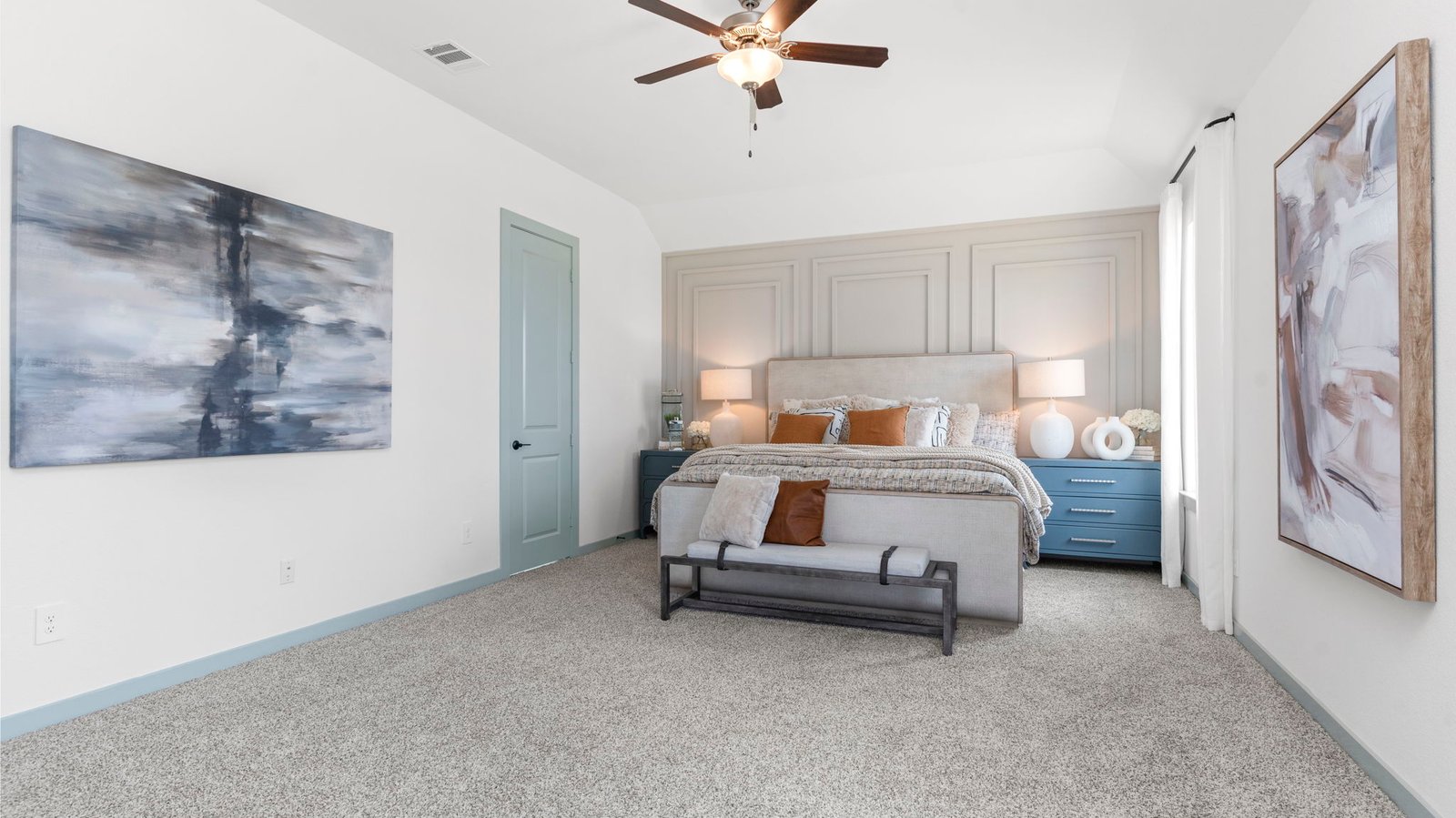 A spacious primary bedroom emphasizing open space and natural lighting with large windows.