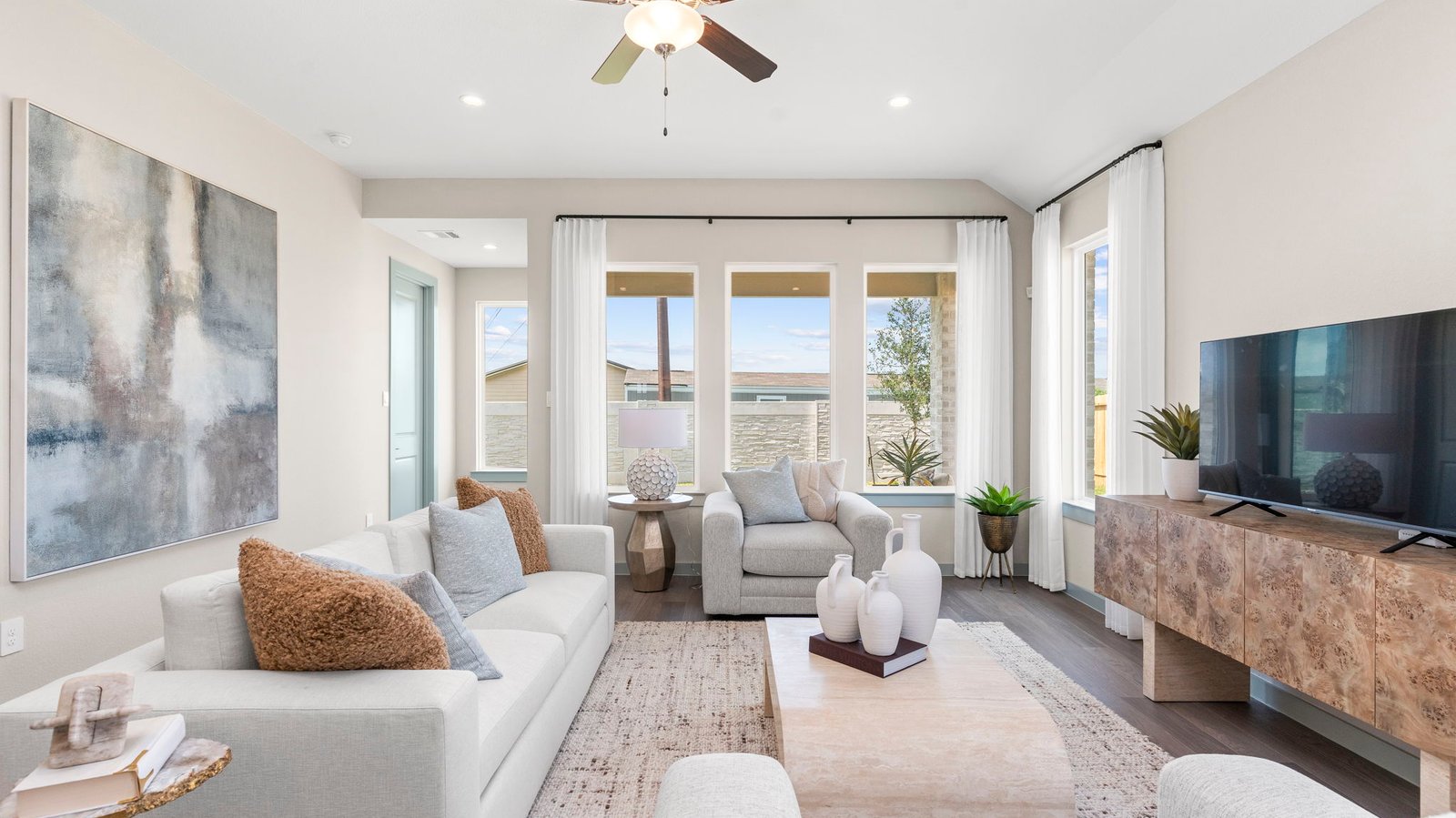 A cozy living room featuring a comfortable couch, a stylish coffee table, and an elegant painting on the wall.