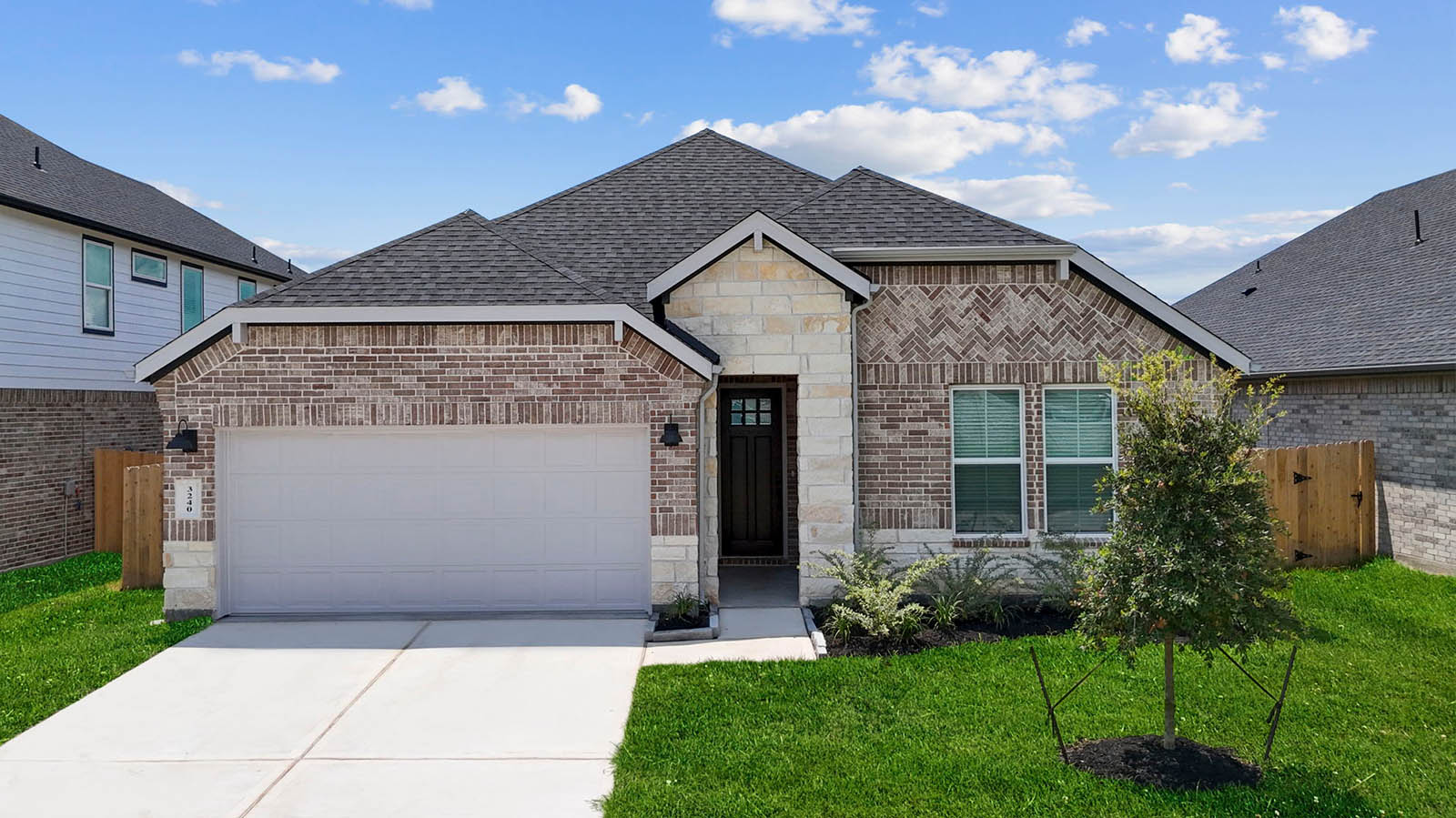 Newly built single story home with traditional architecture, a double garage, and landscaped front yard.