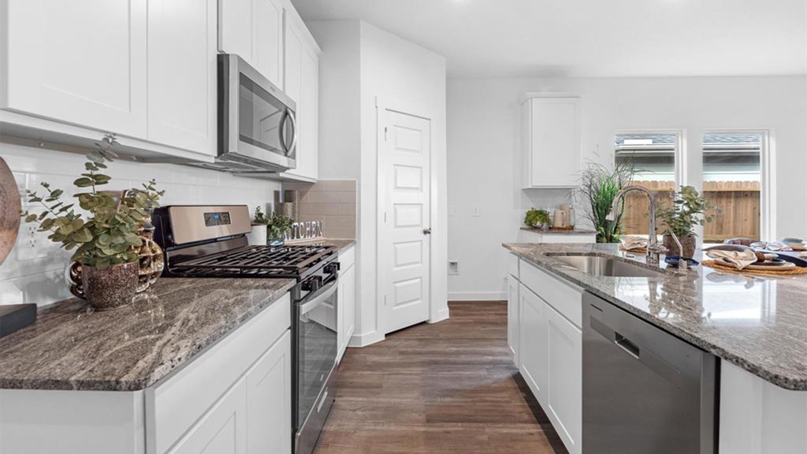 An open concept kitchen with an island with bar seating and access to the living and dining areas.