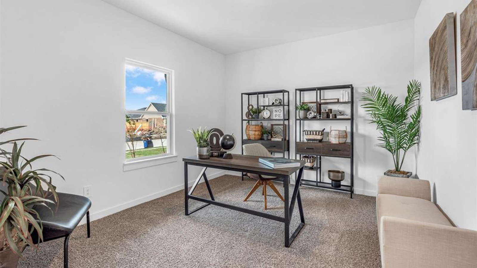 A bedroom shown as an at home office with a bright window allowing natural light to enter.