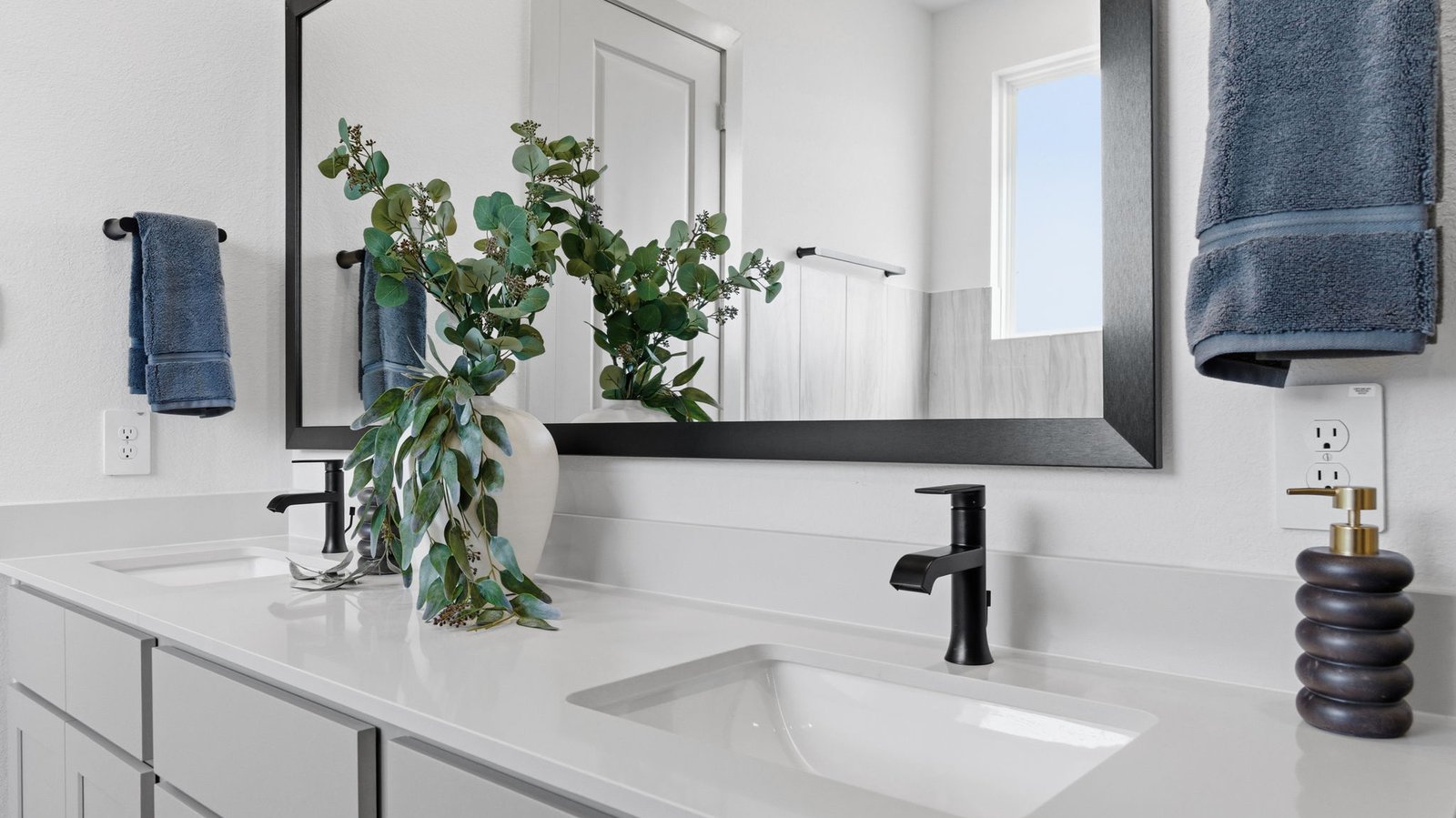 Luxurious primary bathroom with dual vanities, a soaking tub, glass-enclosed shower and walk-in closet.