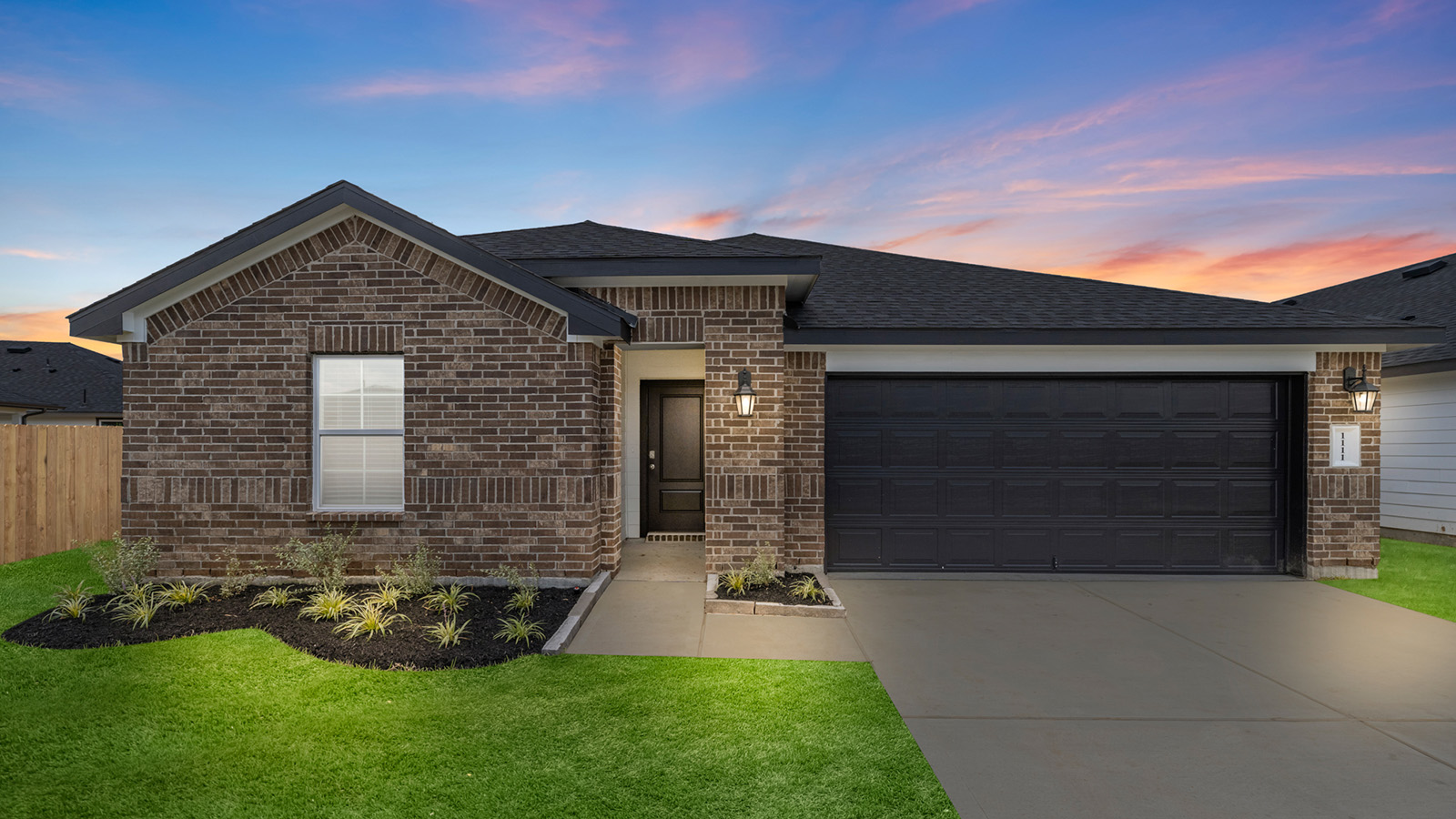 lakeway plan one story brick home at dusk