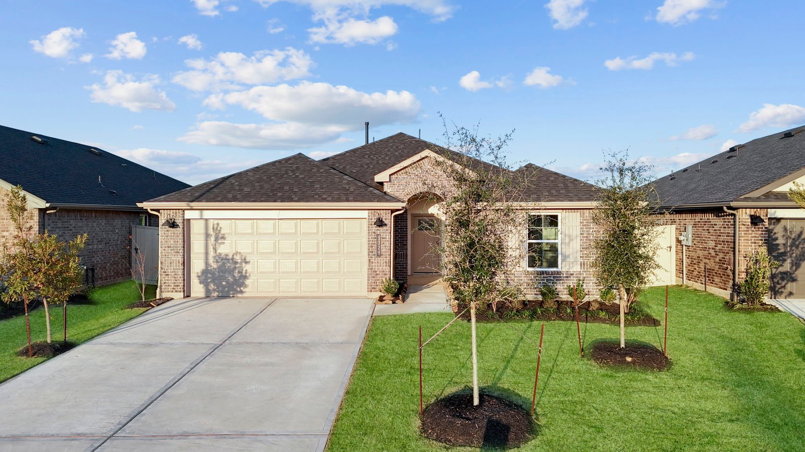 Newly built single story home with traditional architecture, a double garage, and landscaped front yard.