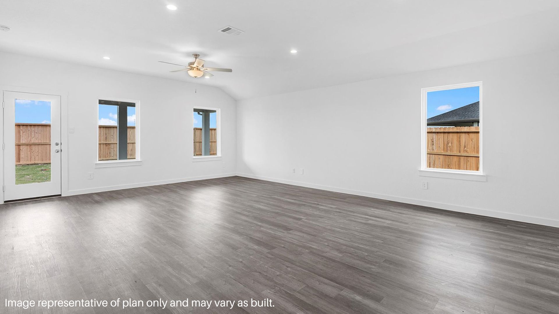 Spacious family room with vinyl flooring and bright windows.