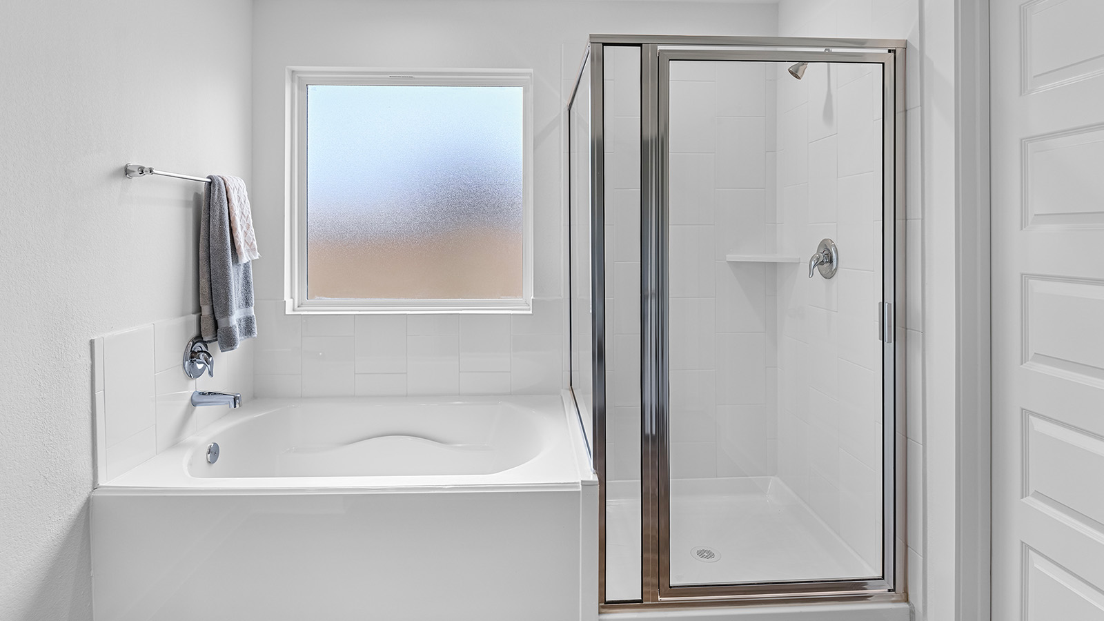 Modern primary bathroom with double vanities, granite countertops, and a glass-enclosed shower with a walk-in closet.