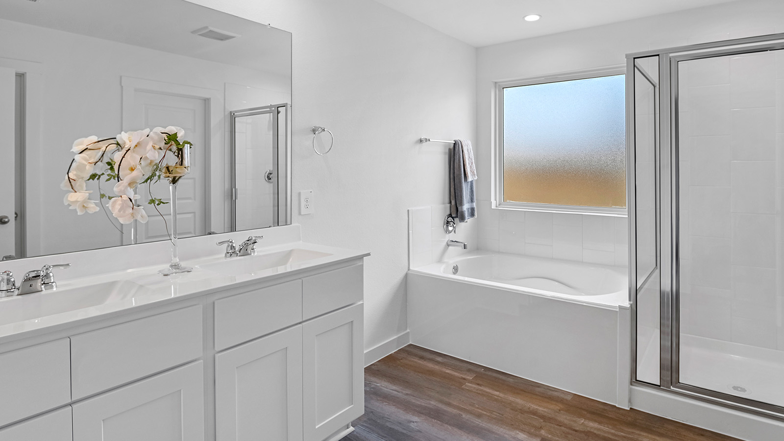 Primary bathroom with a glass-enclosed standing shower and separate soaking tub.
