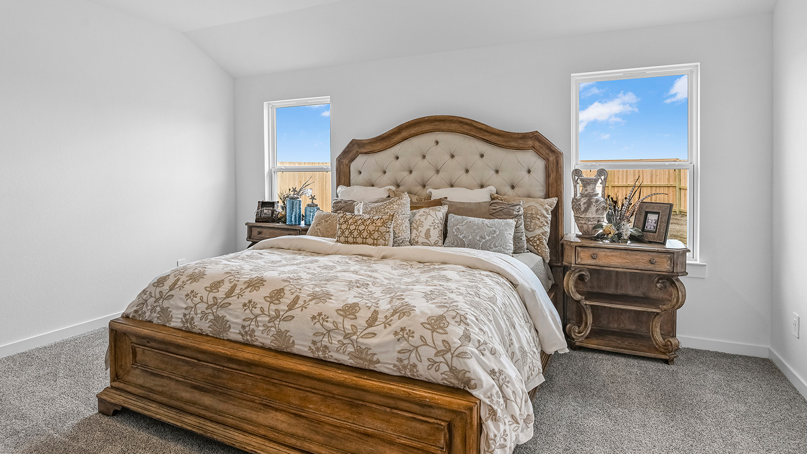 A spacious primary bedroom emphasizing open space and natural lighting with large windows.