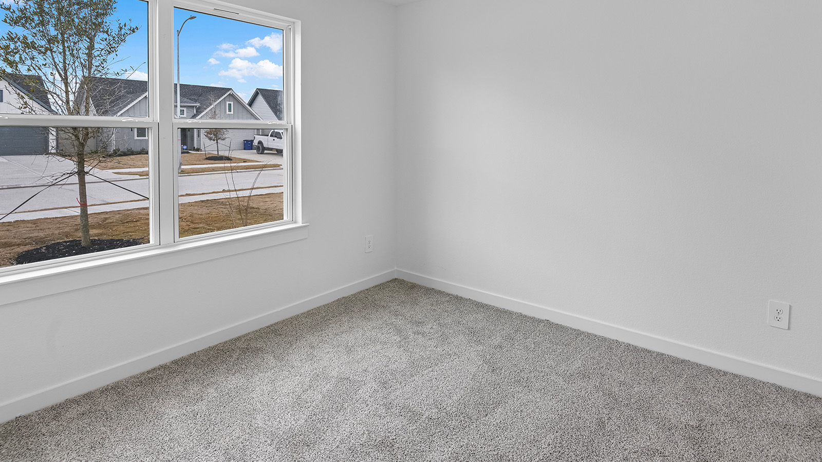 A third bedroom with neutral walls, plush carpet flooring and a separate closet.
