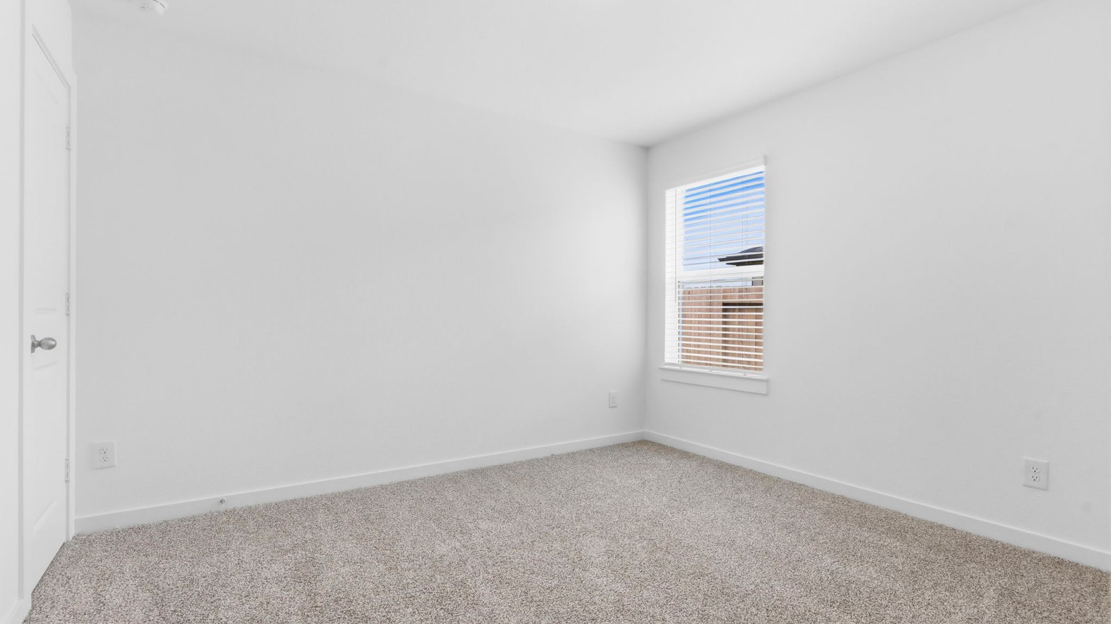 Comfortable guest bedroom featuring neutral-toned walls, carpeted flooring, and a separate closet.