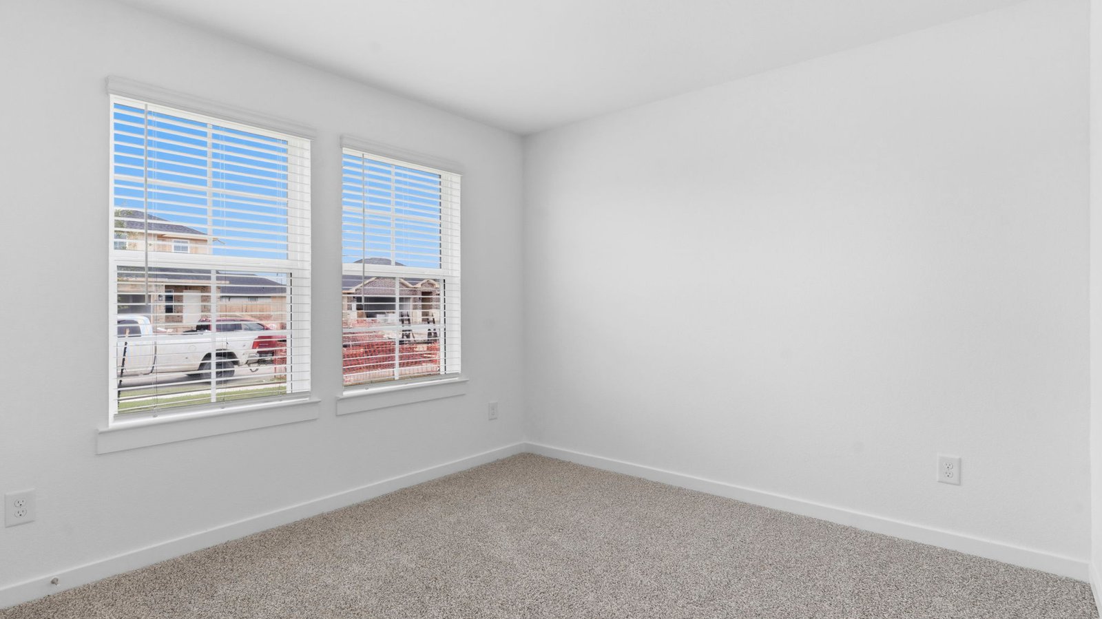 A spacious primary bedroom emphasizing open space and natural lighting with large windows.