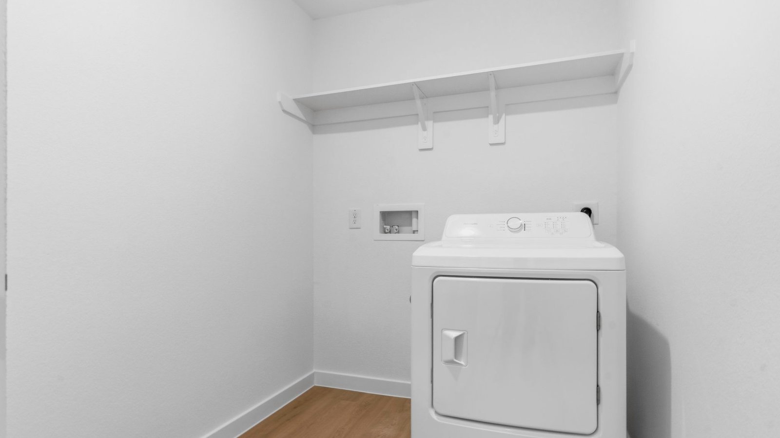 A laundry room featuring washer and dryer connections, neatly arranged with ample space for laundry tasks and storage.