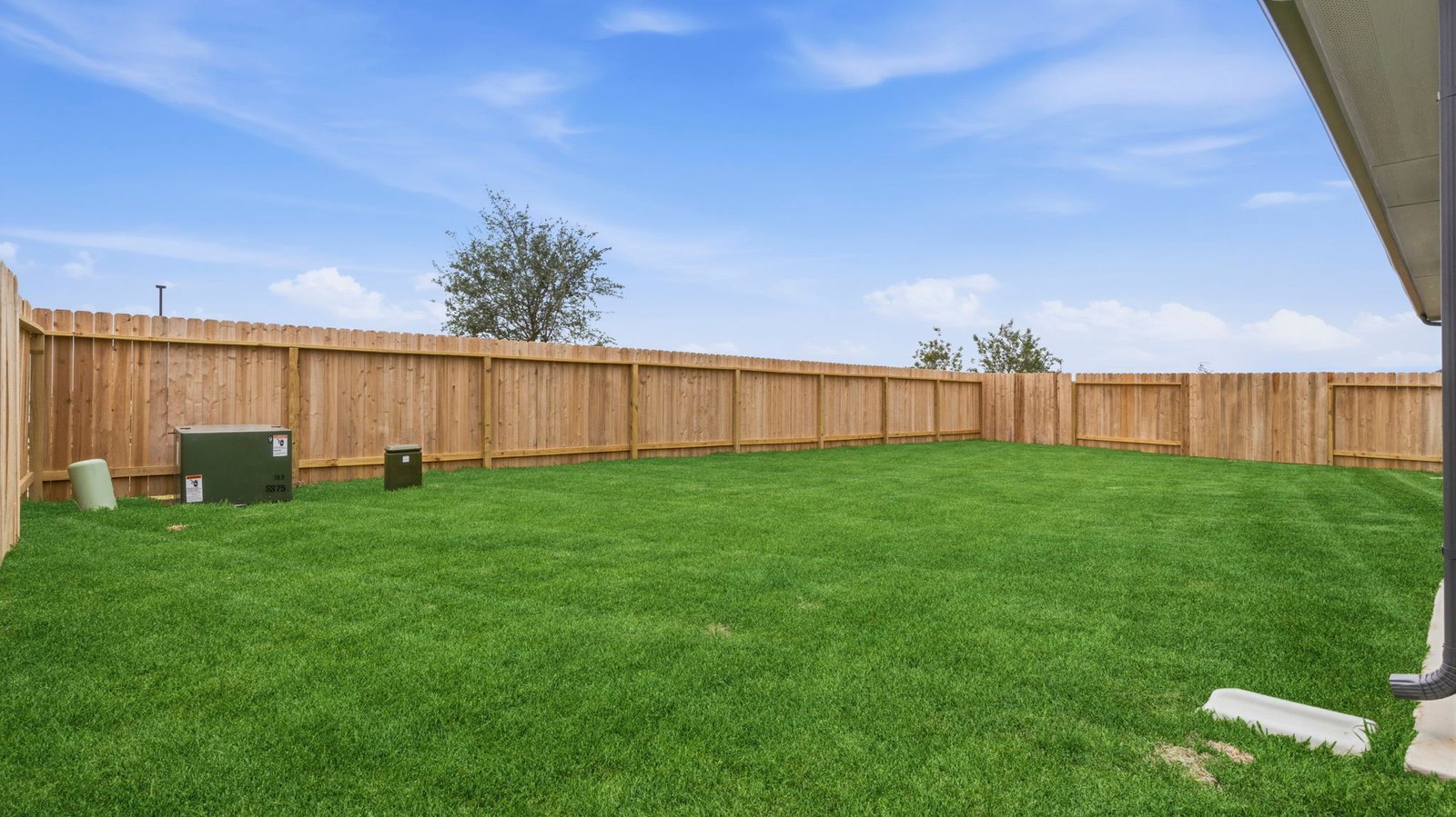 Large fenced-in backyard with a covered patio, perfect for outdoor entertaining.