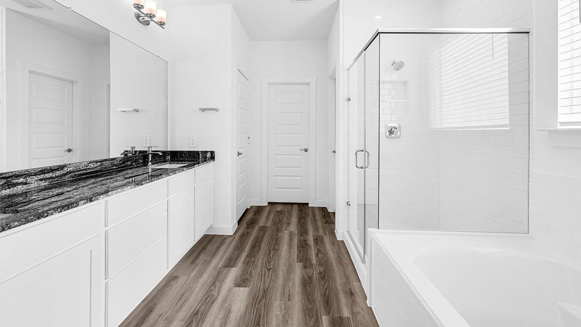 bathroom with dual vanity sinks, toilet, and a walk in shower