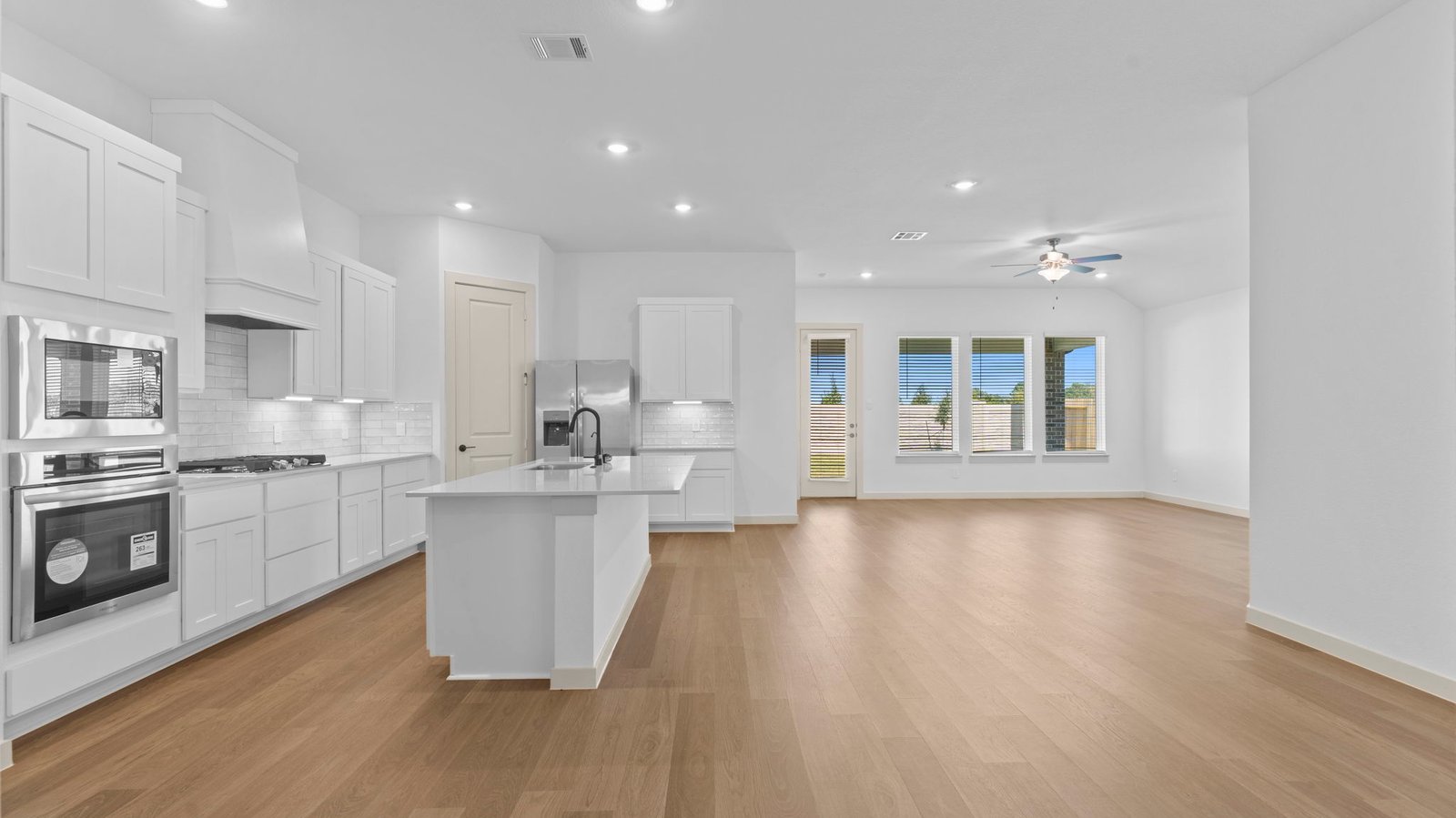 An open concept kitchen with an island with bar seating and access to the living and dining areas.