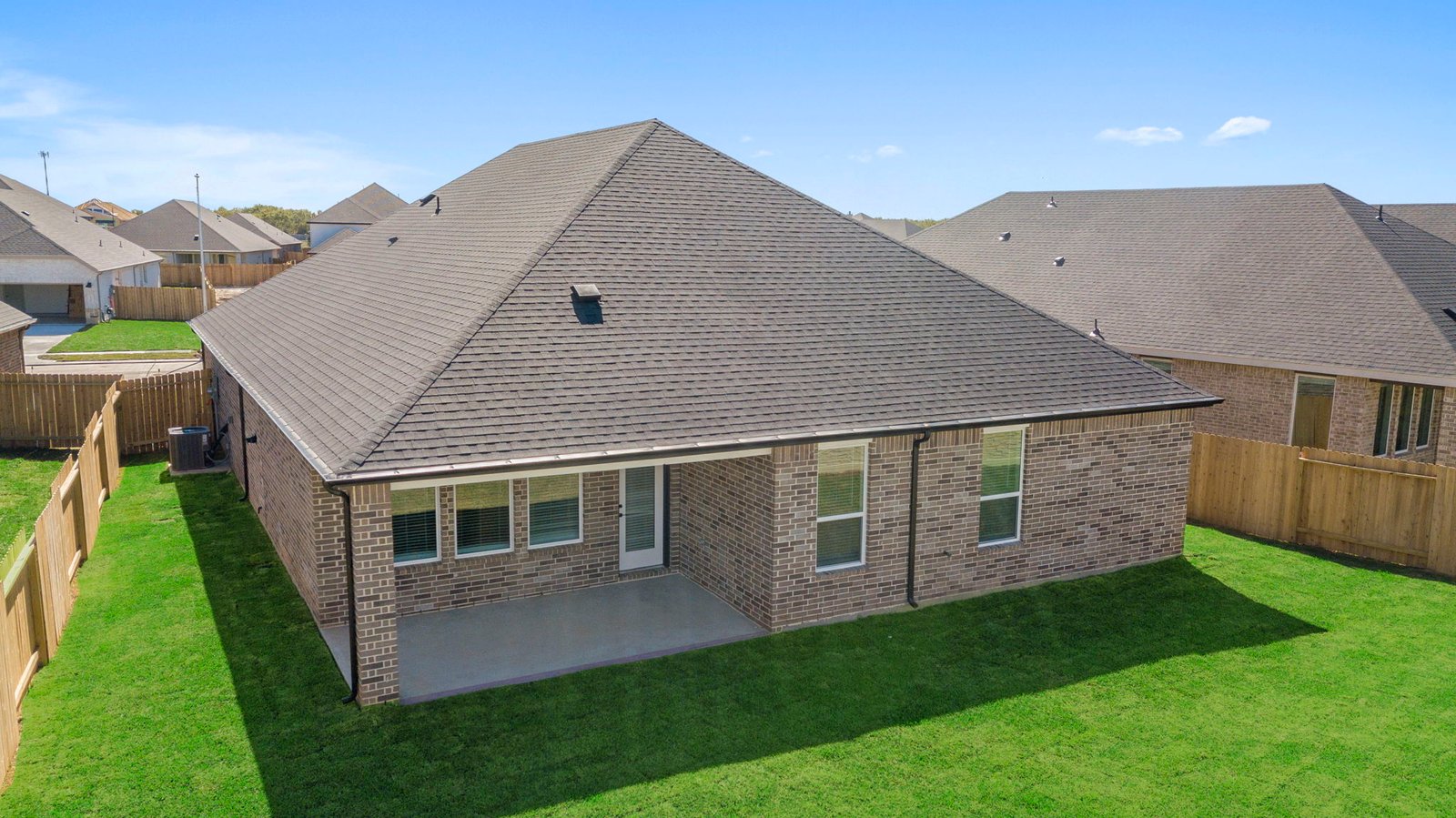 Outdoor covered patio with seating area overlooking a well-maintained lawn, perfect for relaxation.