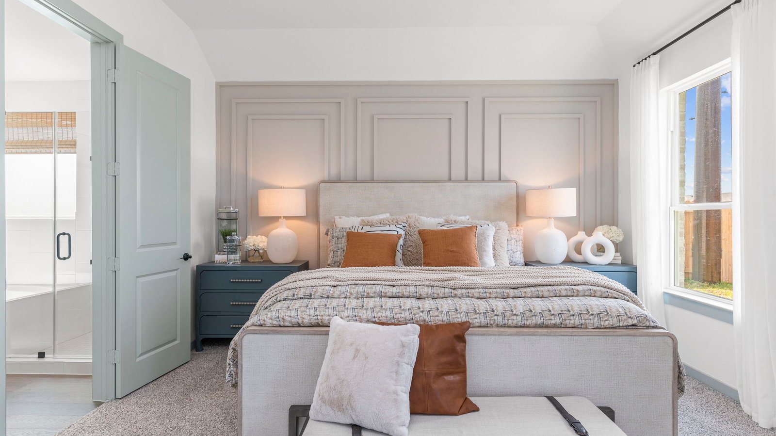 A spacious primary bedroom emphasizing open space and natural lighting with large windows.