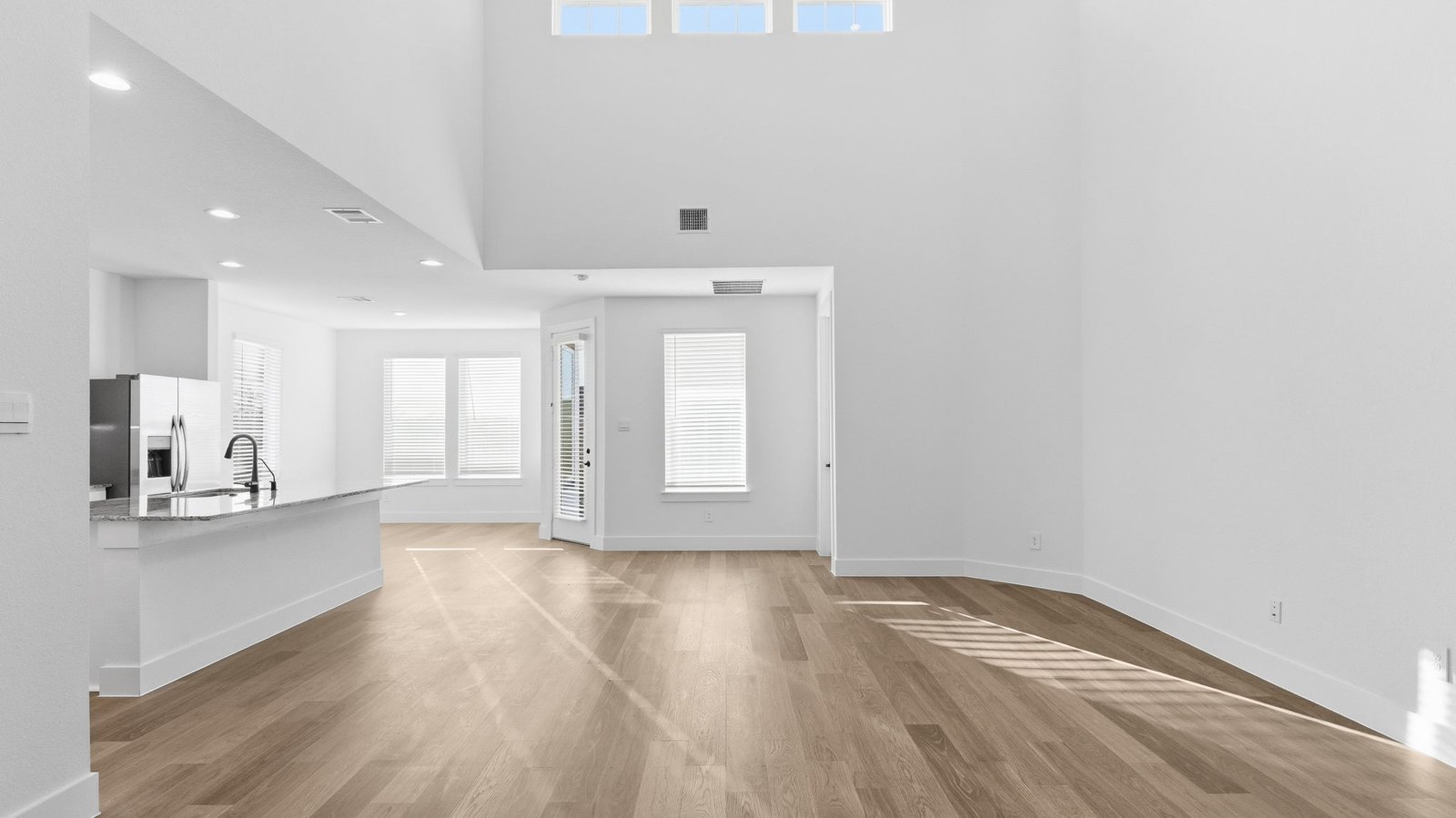 A well-organized living room that includes a kitchen and dining area, creating a warm and welcoming environment for gatherings.