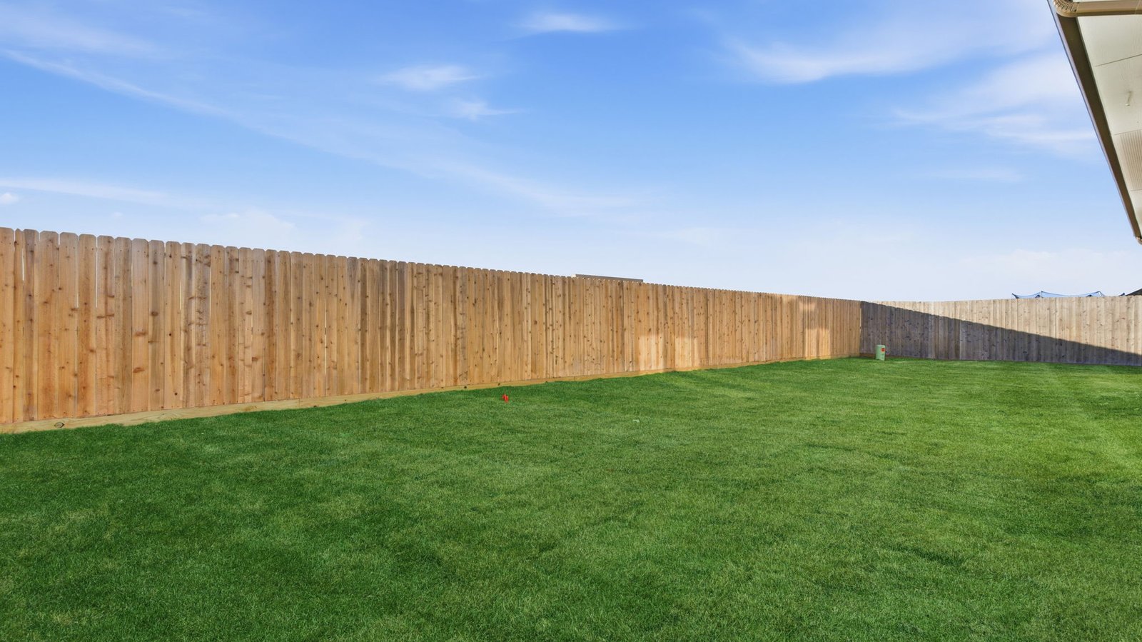 Large fenced-in backyard with a covered patio, perfect for outdoor entertaining.