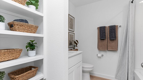 Secondary bathroom with bathtub and shower combo and open shelving