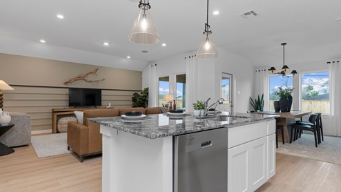Spacious open concept kitchen, dining, and living room with three large windows