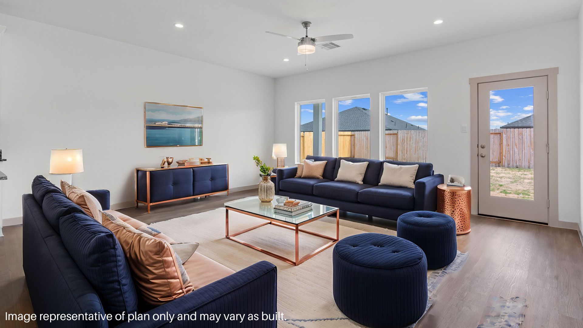 Staged living room with two large windows and backdoor