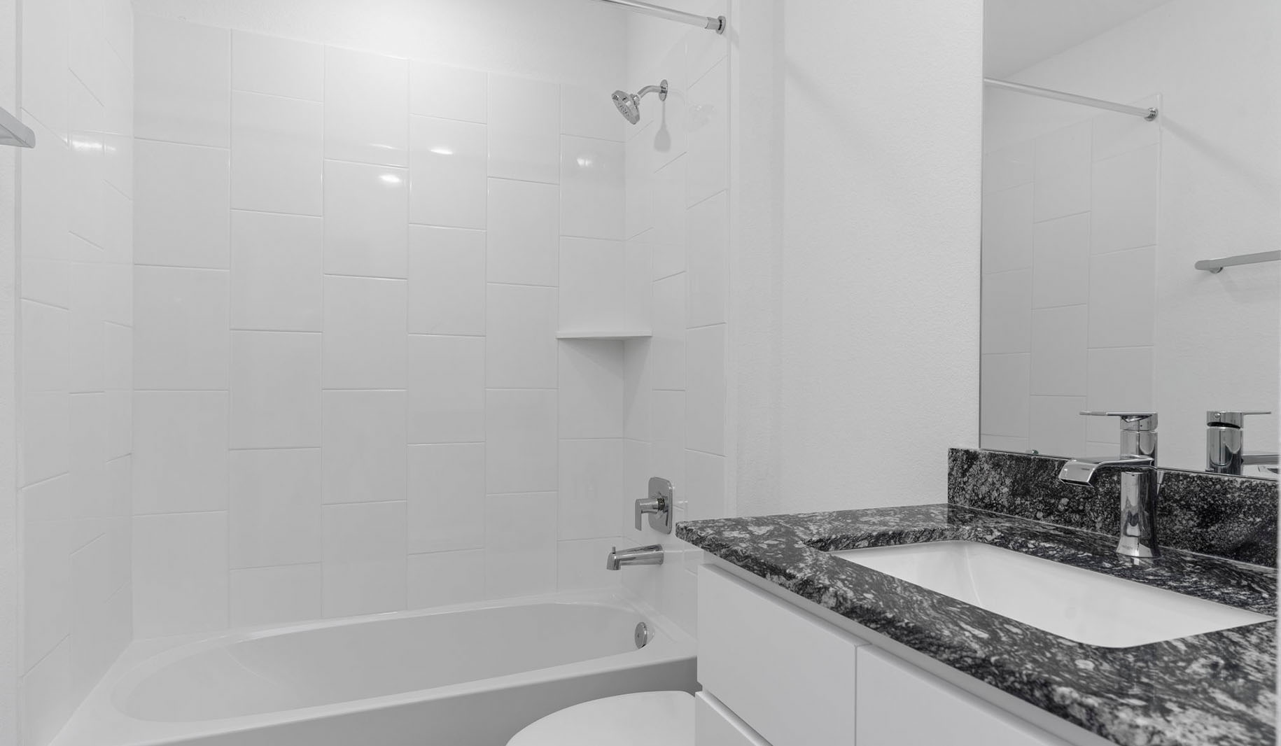 Secondary bathroom vanity with one sink and bathtub and shower combo