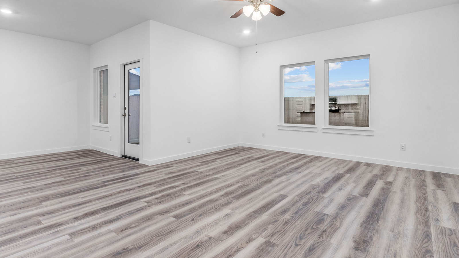 Open concept kitchen and ding room with three large windows