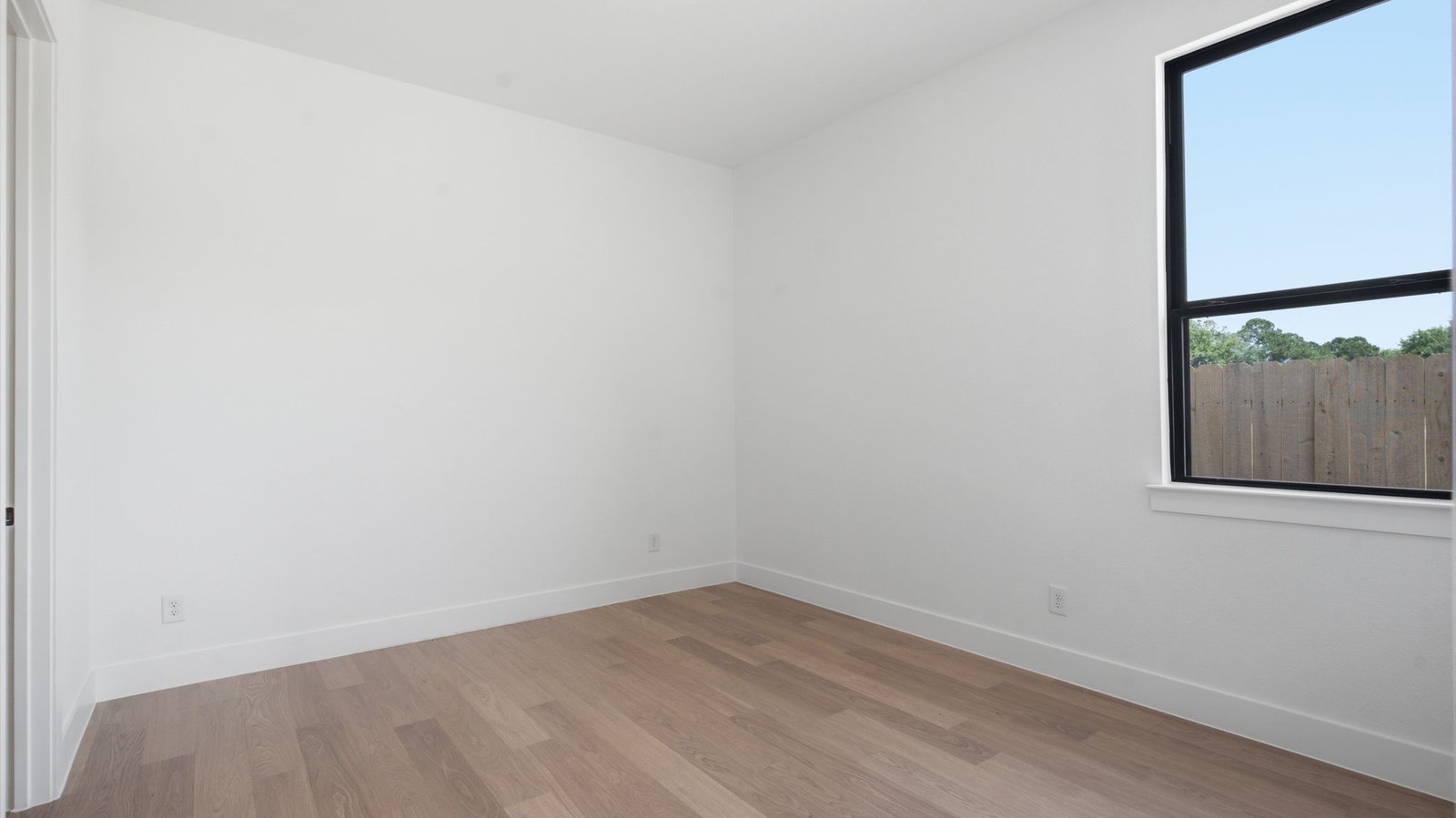 A fourth bedroom with one window, space that fits a queen size bed and additional bedroom furniture