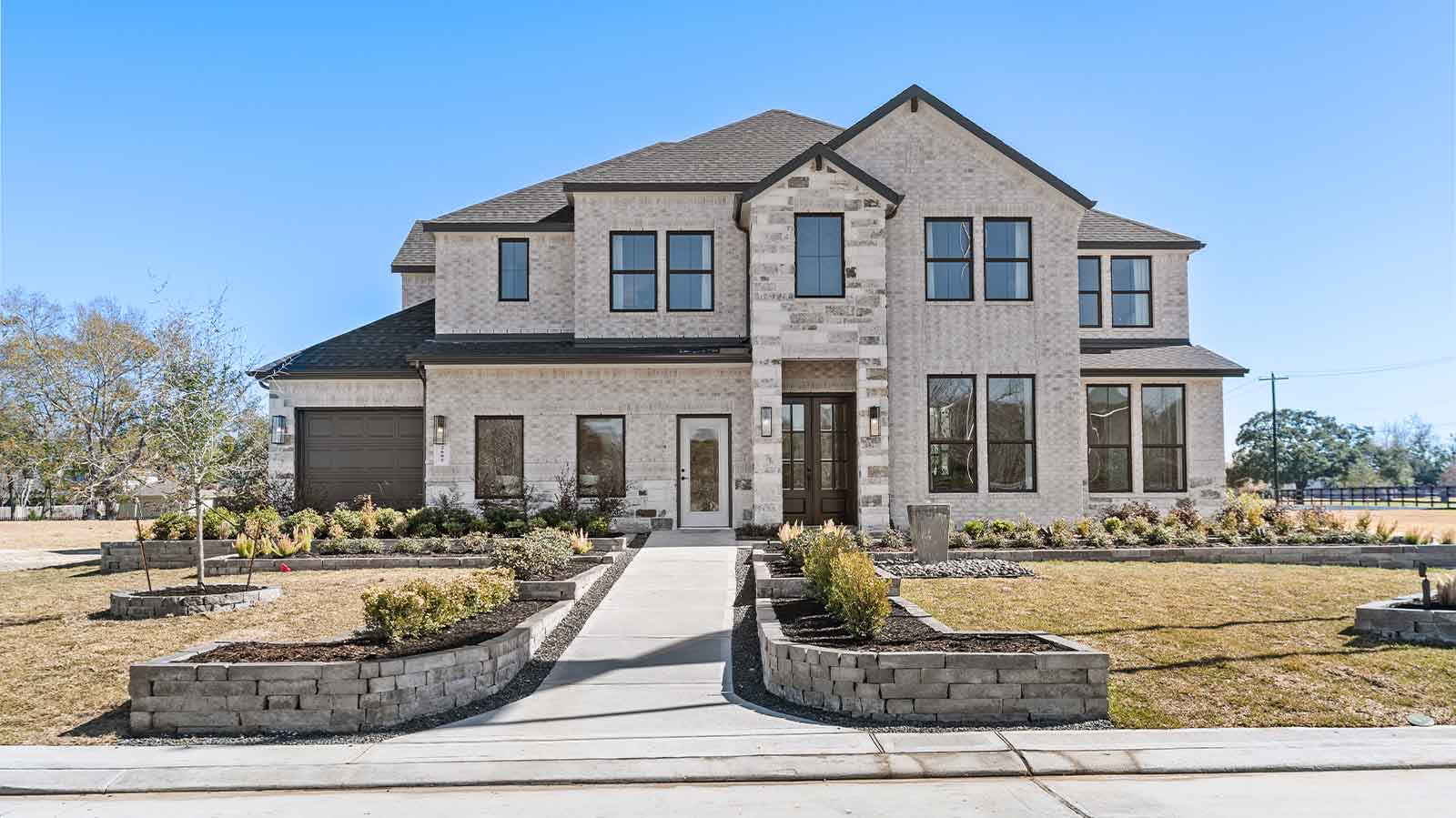 A gorgeous spacious two story home with a modern interior, a covered back patio, five bedrooms, four and a half bathrooms and a three car-garage.