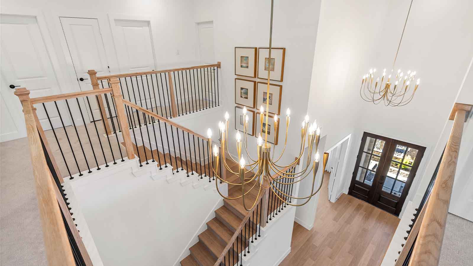 A grand staircase leading to the second floor with a luminating chandelier