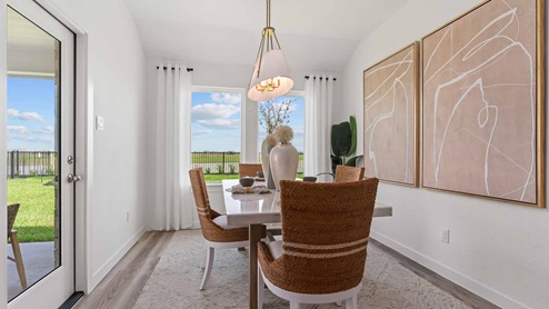Gorgeous dining room nook with two windows on the back wall and door to backyard patio
