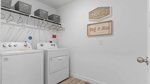 Laundry room with above washer shelving with hanging rod