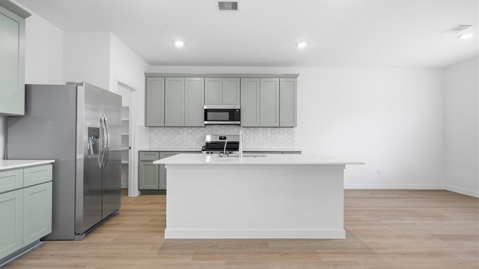 open concept kitchen with large island and walk in pantry