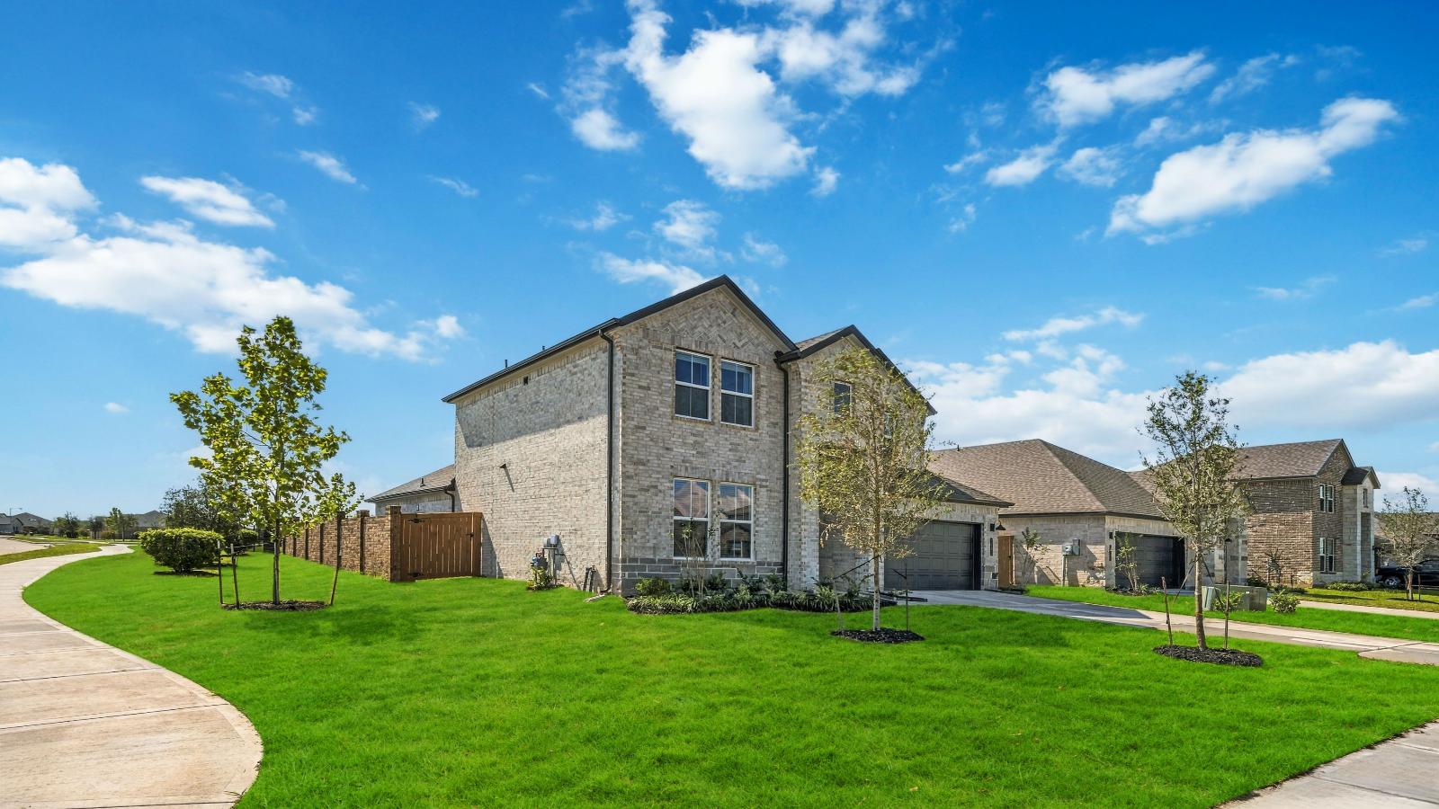 Newly built two story home with traditional architecture, a double garage, and landscaped front yard.