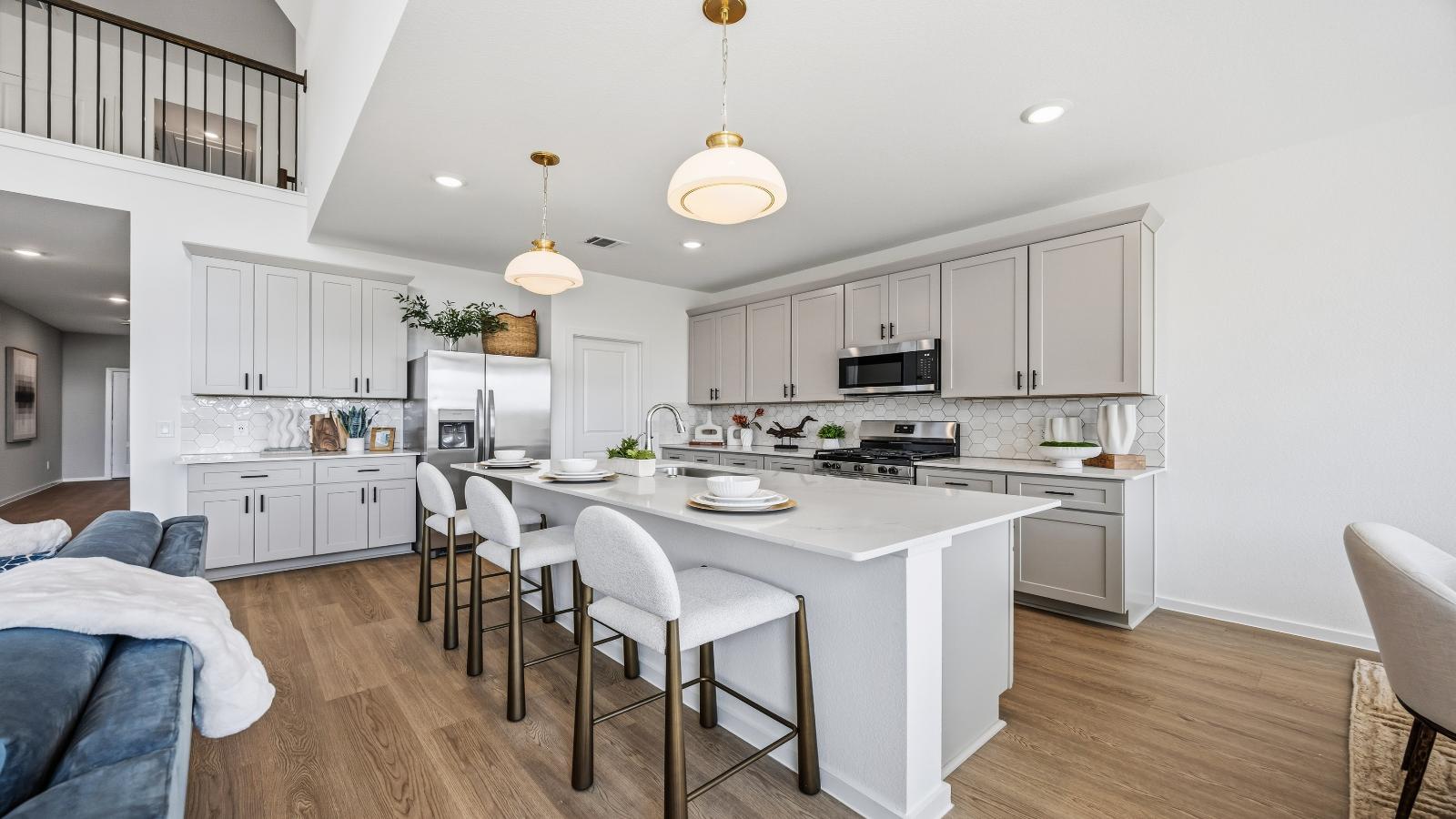Bright and spacious kitchen with quartz countertops, stainless steel appliances, and an island with bar seating.