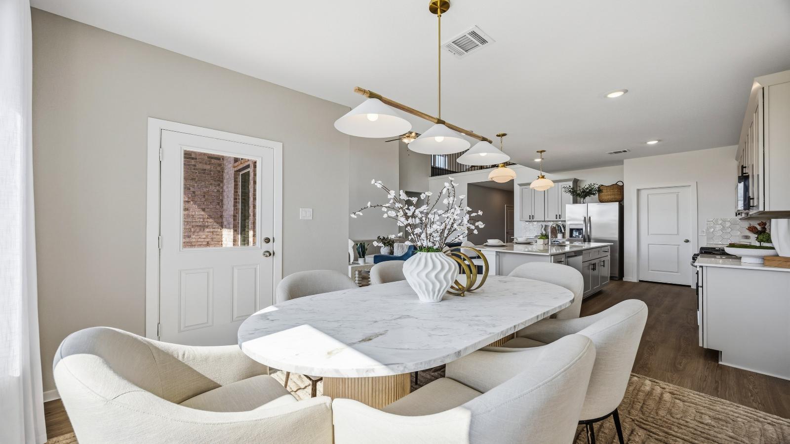 Formal dining area with large windows, vinyl wood floors, and view of the backyard.