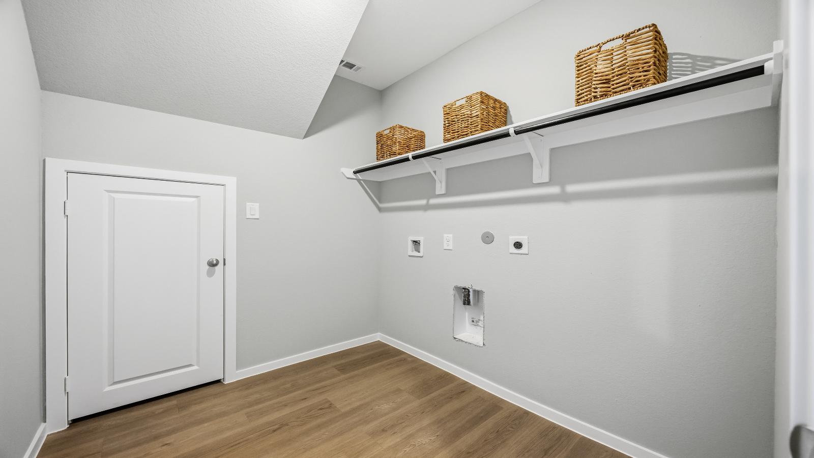 A laundry room featuring washer and dryer connections, neatly arranged with ample space for laundry tasks and storage.