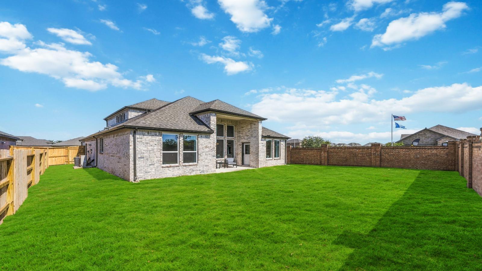 Large fenced-in backyard with a covered patio, perfect for outdoor entertaining.