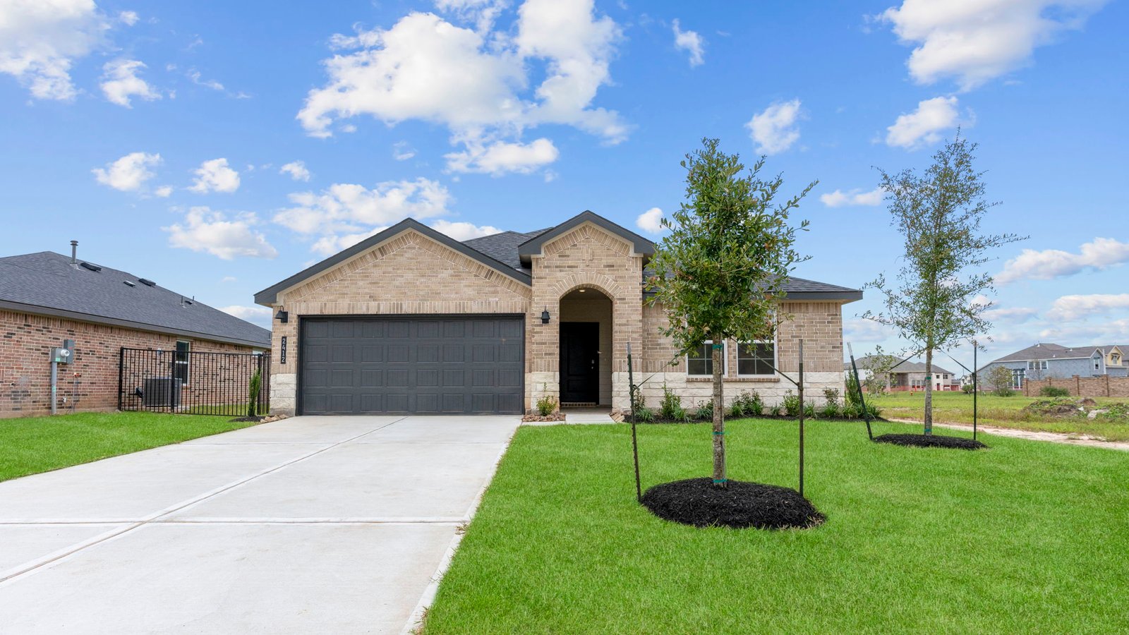Newly built single story home with traditional architecture, a double garage, and landscaped front yard.