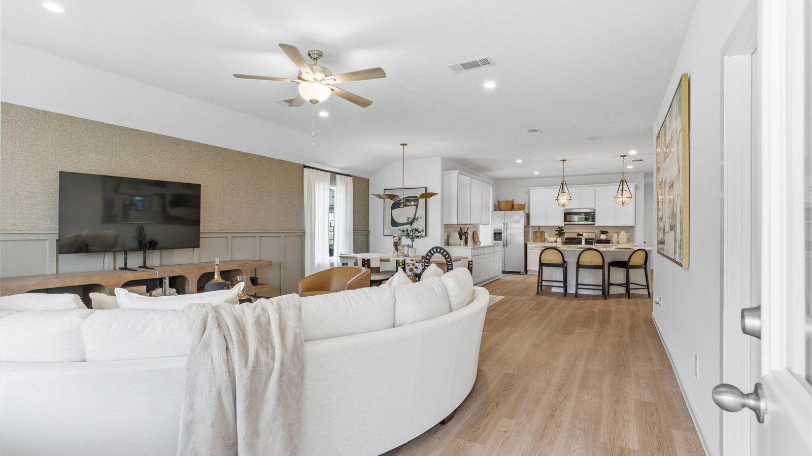 A well-organized living room that includes a kitchen and dining area, creating a warm and welcoming environment for gatherings.